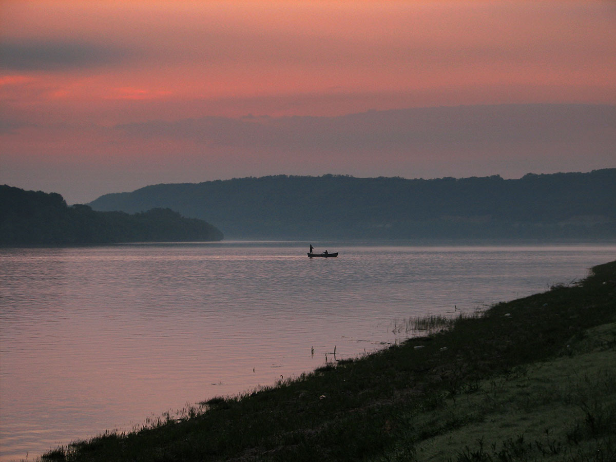 Abendstimmung an der Donau mit einem Fischerboot in der Flussmitte