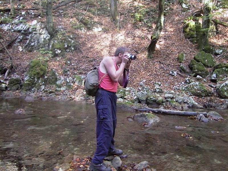 Willi steht am Fluss und fotografiert