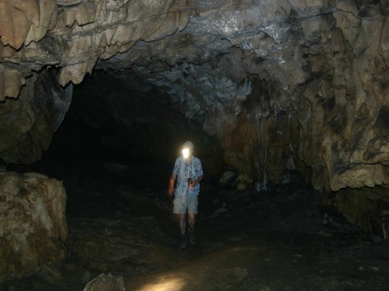 Wanderer in Höhle mit Stirnlampe
