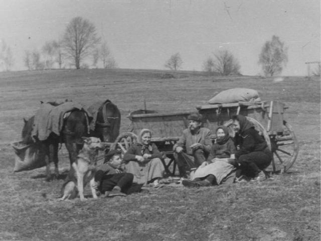 historisches Foto von Bauern auf dem Fels sitzend vor einem Pferdewagen