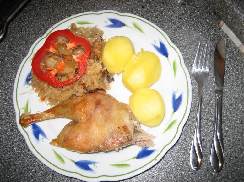 Ente auf dem Teller mit Sauerkraut und Kartoffeln serviert