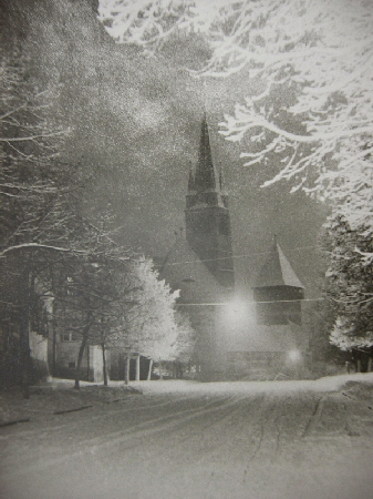 verschneite Straße mit Kirche im Hintergrund