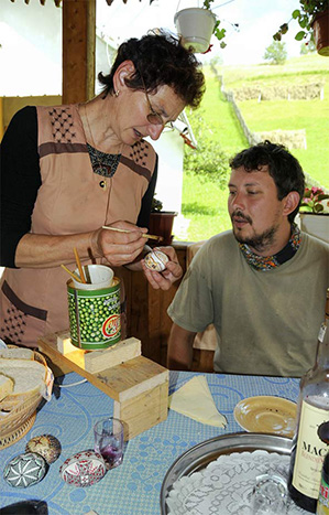 Frau bemalt mit einem Pinsel ein Ei