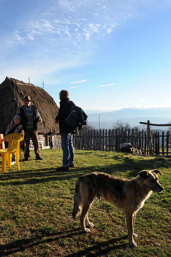 Menschen vor Holzhaus