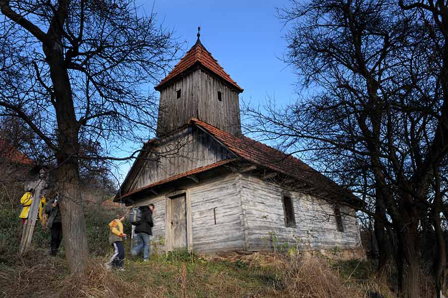 Mann vor Holzkirche