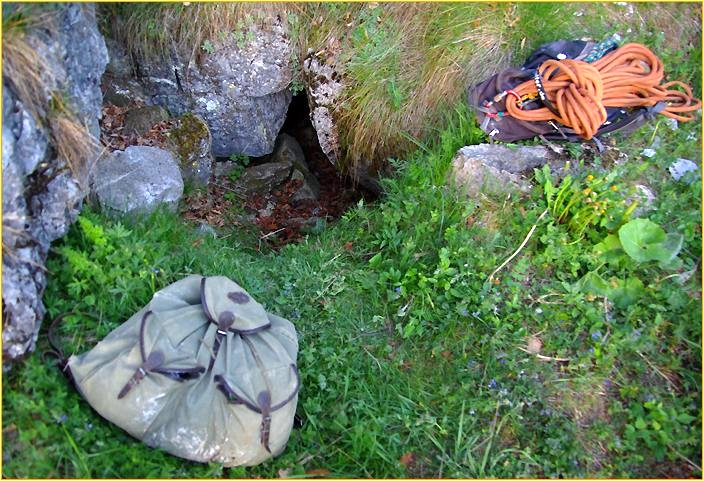 Rucksack und Seil neben Höhleneingang