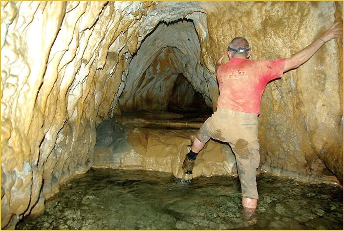 Mann steigt durch Fluss in Höhle