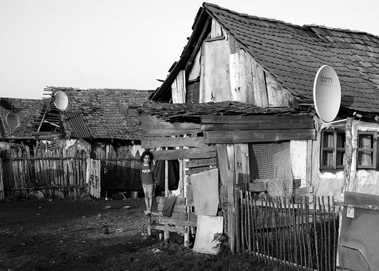 Mädchen vor Holzhaus