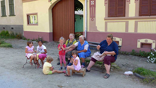 Menschen sitzen vor einem Haus