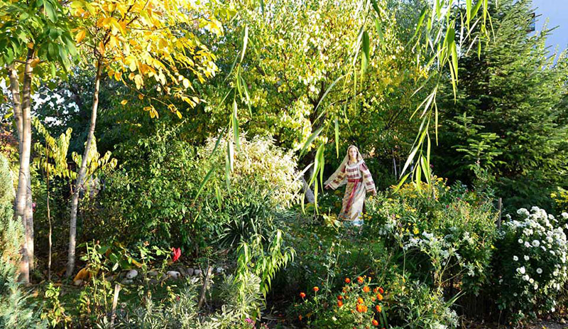 Silvia steht mit Tracht in einem blühenden Garten