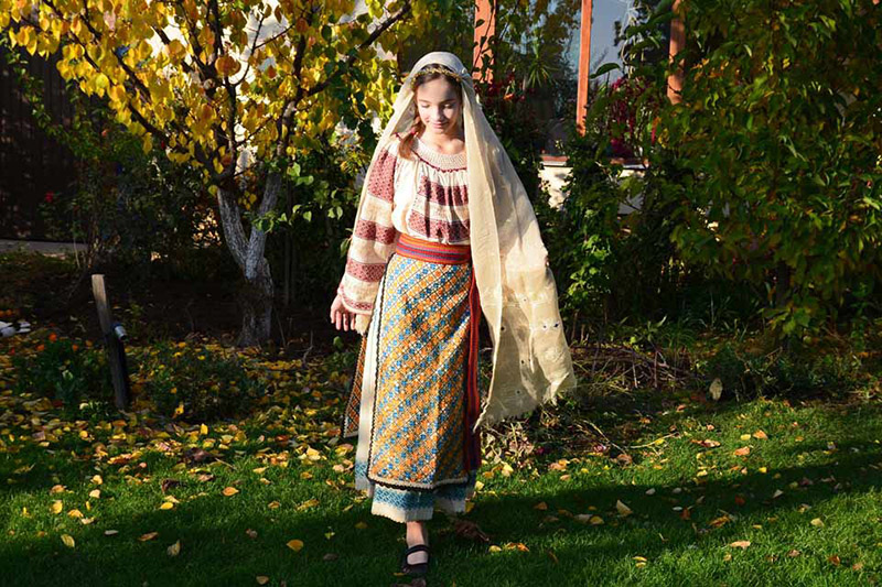 Silvia läuft mit einer Tracht durch einen Garten