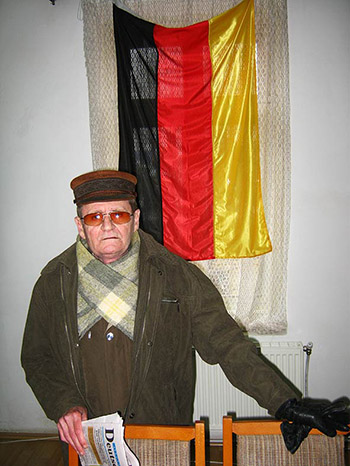 Mann steht vor einer Deutschlandfahne