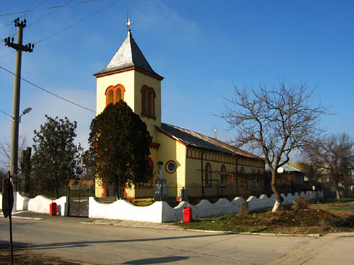 gelbe Dorfkirche mit weißer Mauer drum herum