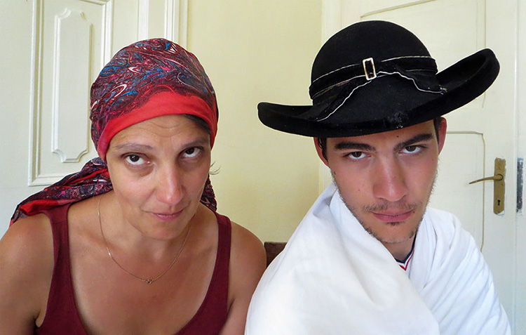 Mann mit Romahut und Frau mit Kopftuch schauen in die Kamera
