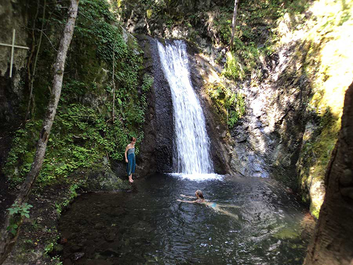 Mädchen badet im See am Wasserfall