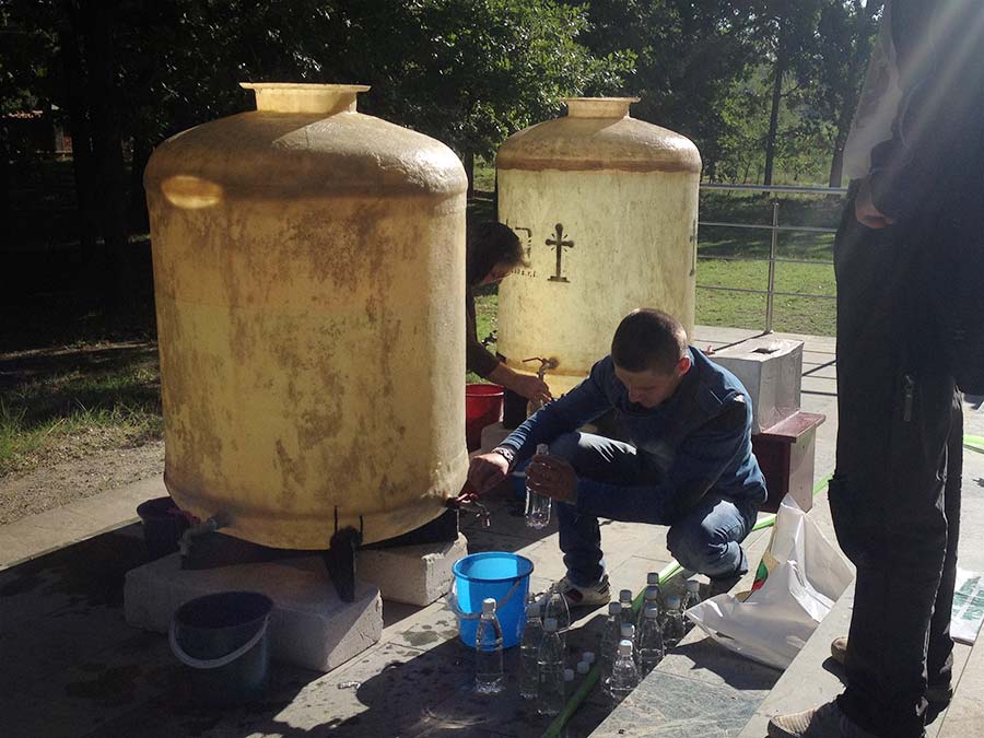 Mann füllt en einem Wassertank Wasser ab