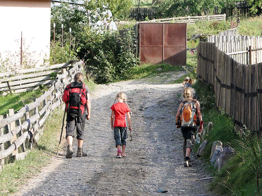 Familie wandert auf einem Weg im Dorf