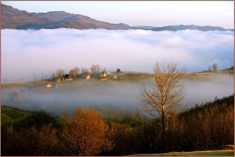 Dorf in Berglandschaft mit Nebel