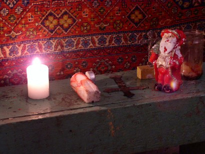 kleiner selbstgebauter Altar mi Kerze, Weihnachtsmann und einem Kreuz