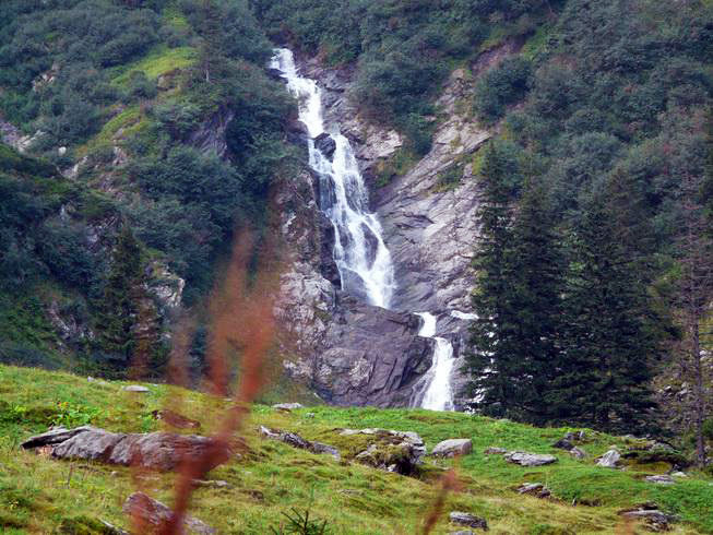 großer Wasserfall hinter einer Wiese