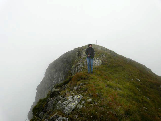 Codruta steht vor Felsspitze im Nebel