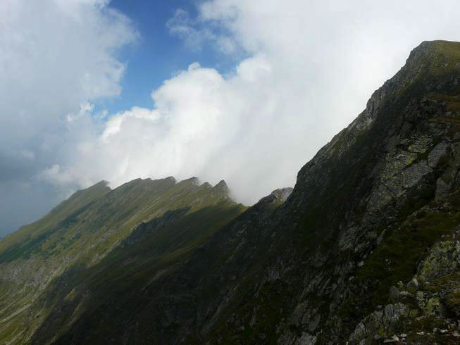 Bergrücken auf der einen Seite mit Sonne und auf der anderen Seite mit Wolken