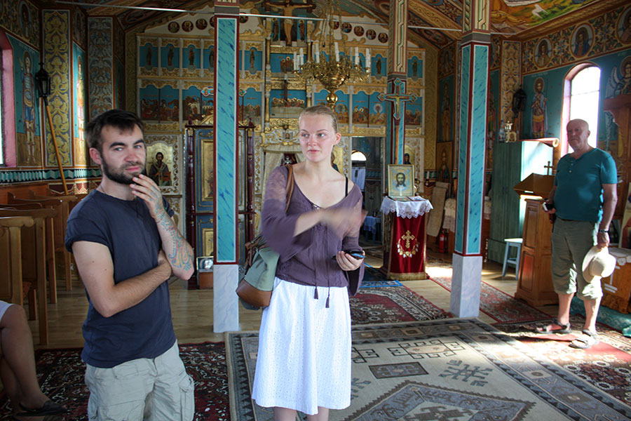 Besucher stehen in einer orthodoxen Kirche