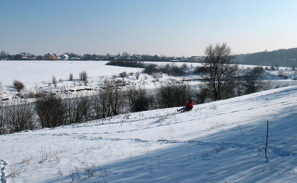 Kind rodelt einen Berg herunter