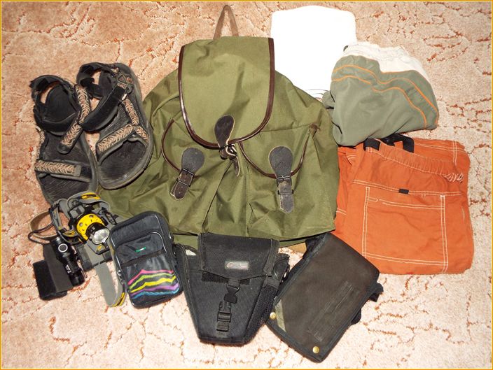 Kleiner Rucksack mit Sandalen, Kamera, Taschenlampe und einigen anderen Utensilien