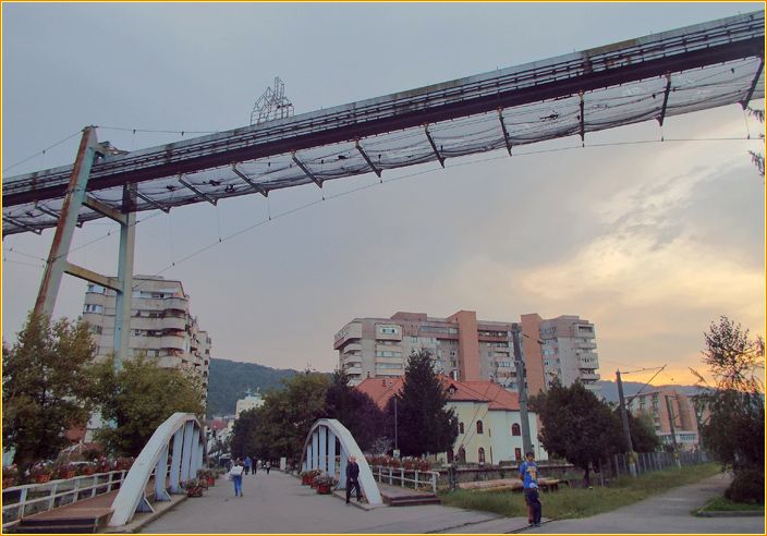 Förderbrücke neben Hochhäußern mitten in der Stadt