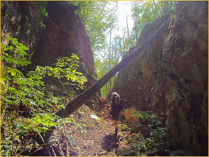 Hans wandert durch eine Schlucht gefüllt mit Steinbrocken auf der ehemaligen Eisenbahnlinie