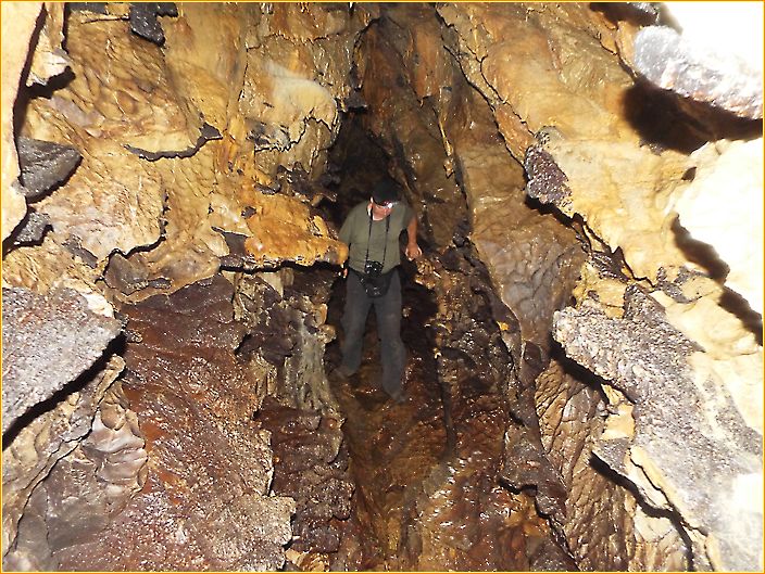 Hans klettert durch eine schmale Höhle