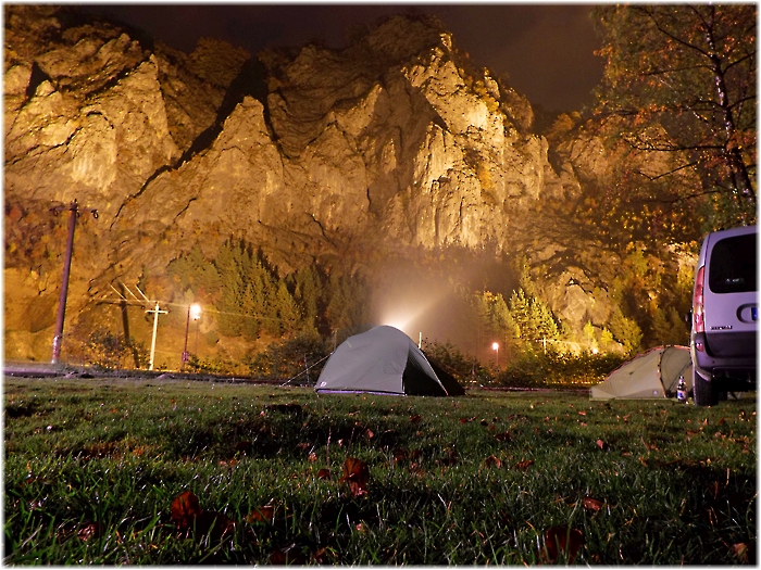 Zelt steht vor einer beleuchtender Felswand