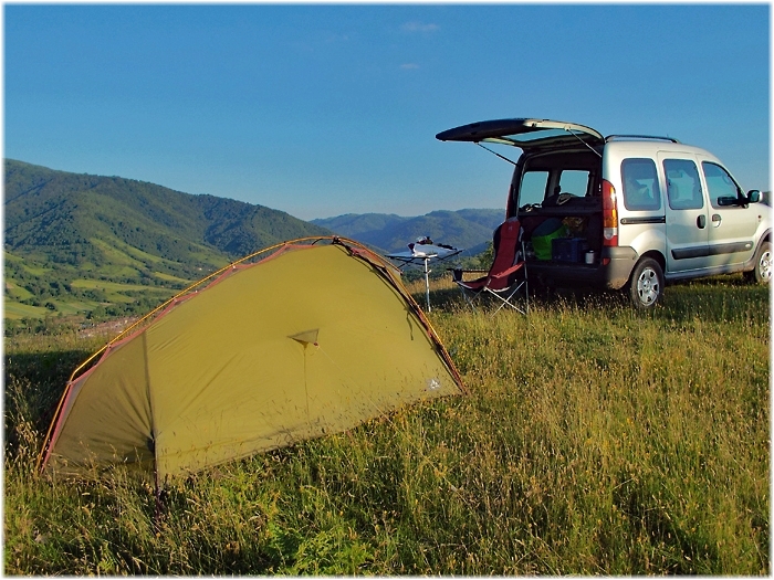 Zelt und Auto auf einem Bergkamm
