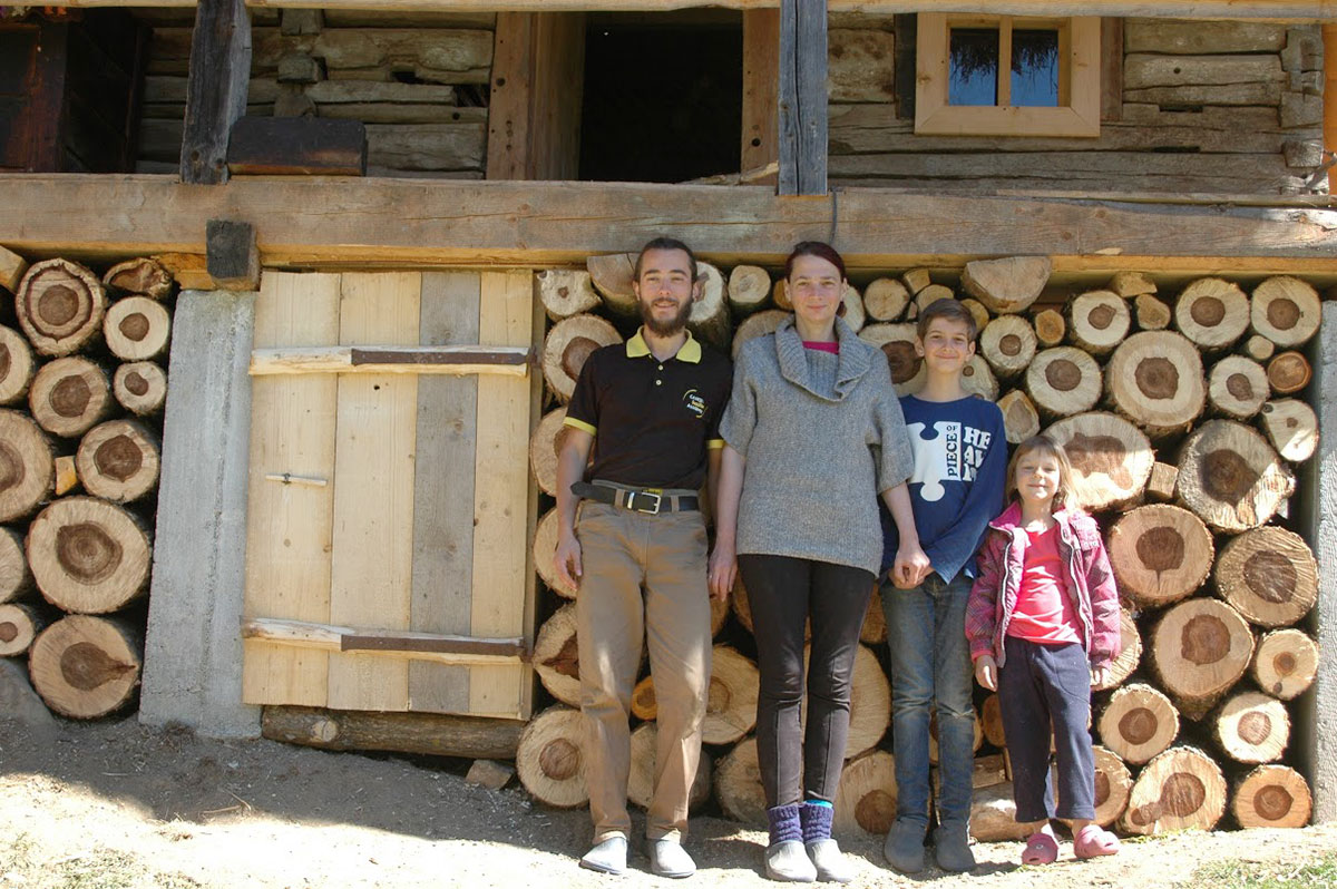 Familie Sulimann steht vor Holzhaus