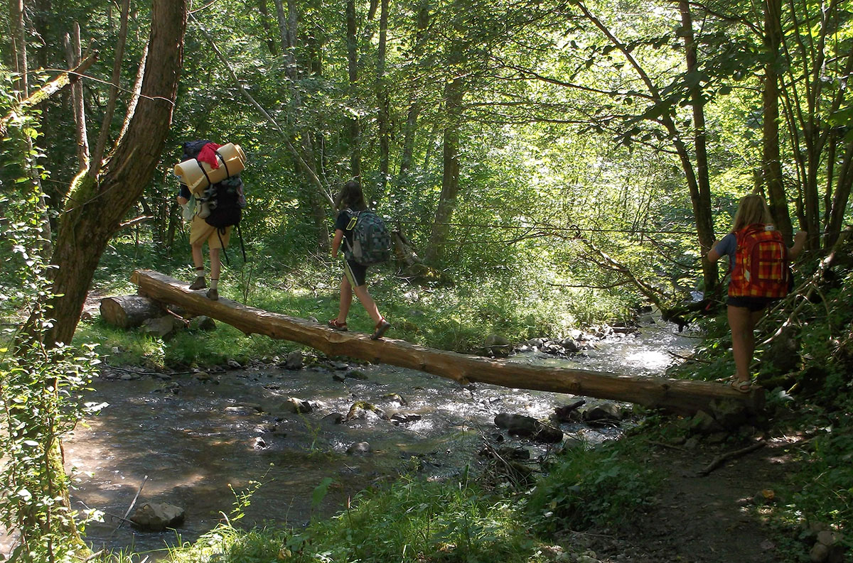 Familie überquert Holzbrücke