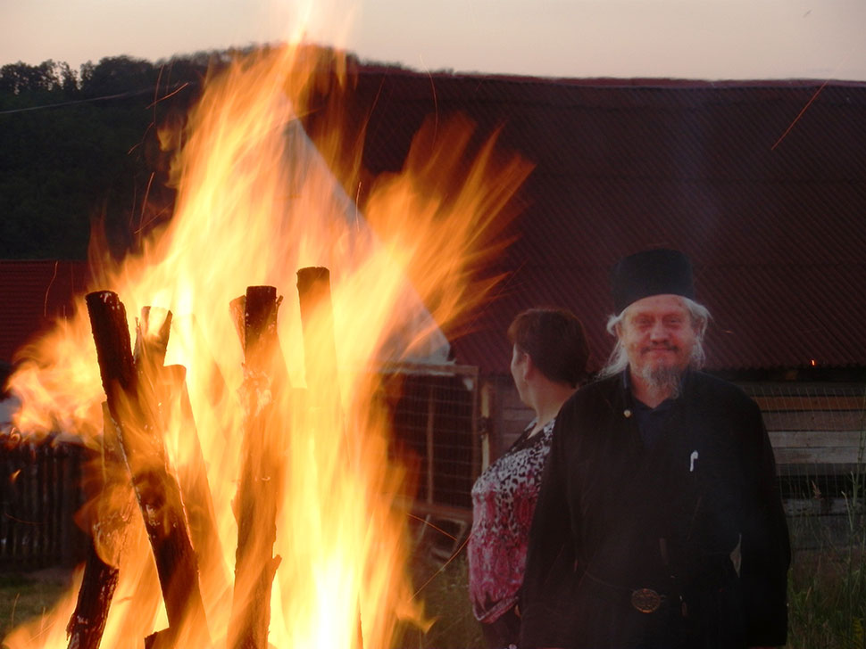 Mönch neben Lagerfeuer