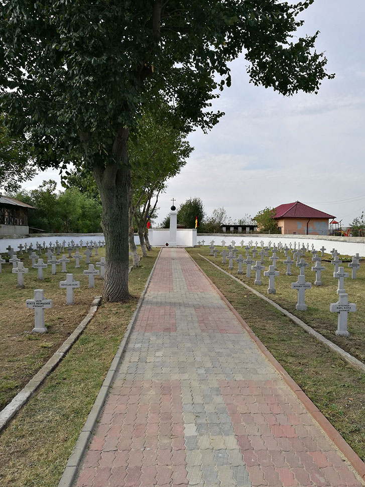 Weg auf Friedhof mitten zwischen Kreuzen