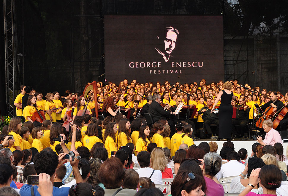 Bühne mit vielen Chorkindern in gelben T-Shirts während eines Konzertes