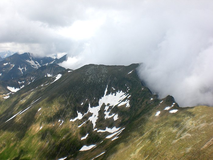 Bergkamm auf der einen Seite in Wolken gehüllt und auf der anderen Seite mit klarer Sicht.