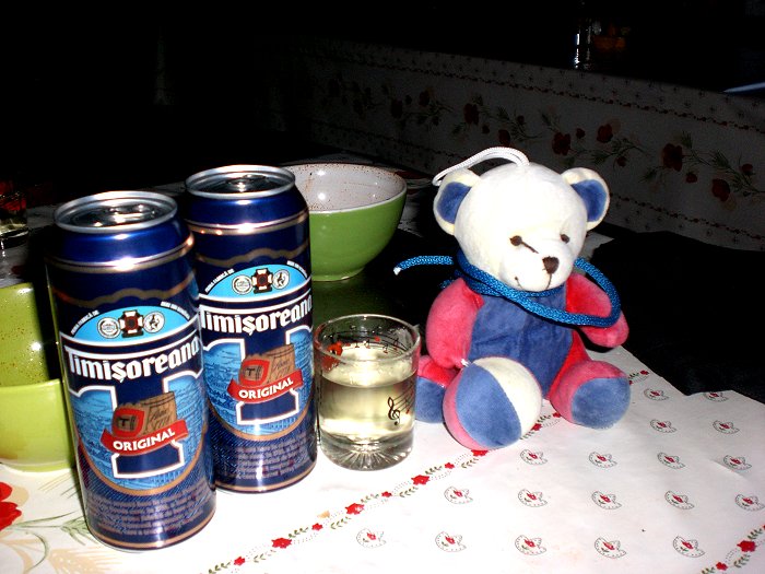 Bierbüchsen stehen auf einem Tisch neben einem Glas und einem Teddy