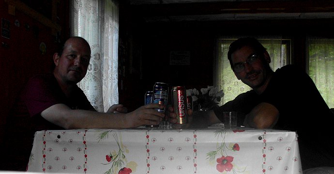 Stefan und sein Mitwanderer sitzen mit zwei Büchsen bier in der Hand an einem Tisch