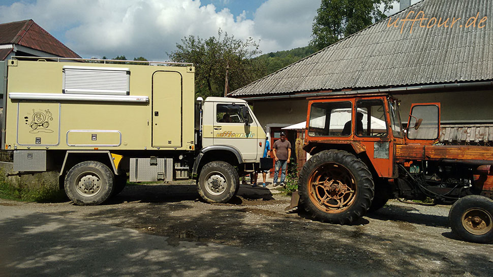 Wohnmobil-LKW steht wieder gerade auf dem Platz neben einem Traktor