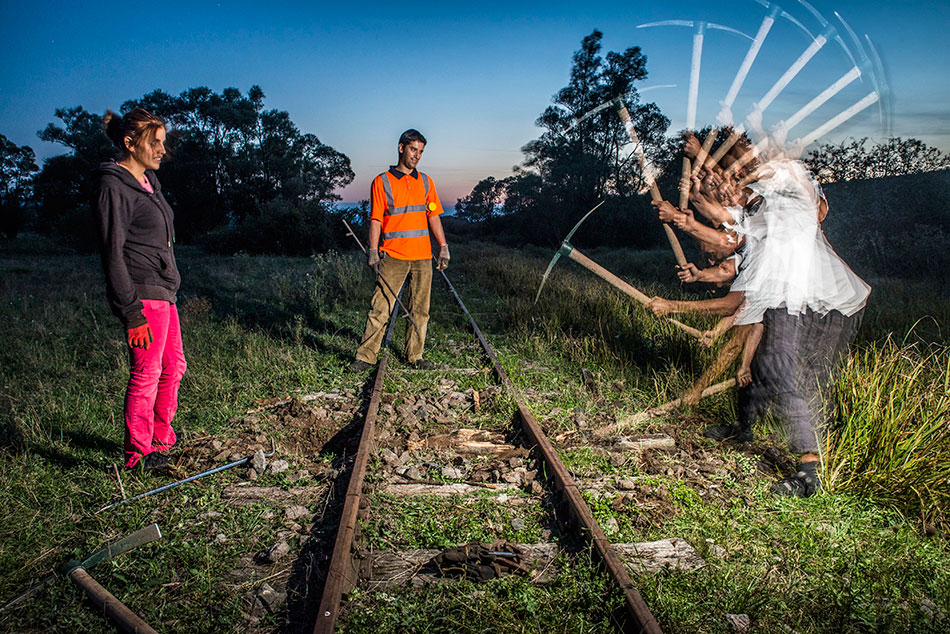 Freiwillige arbeiten mit Hacke am Gleis