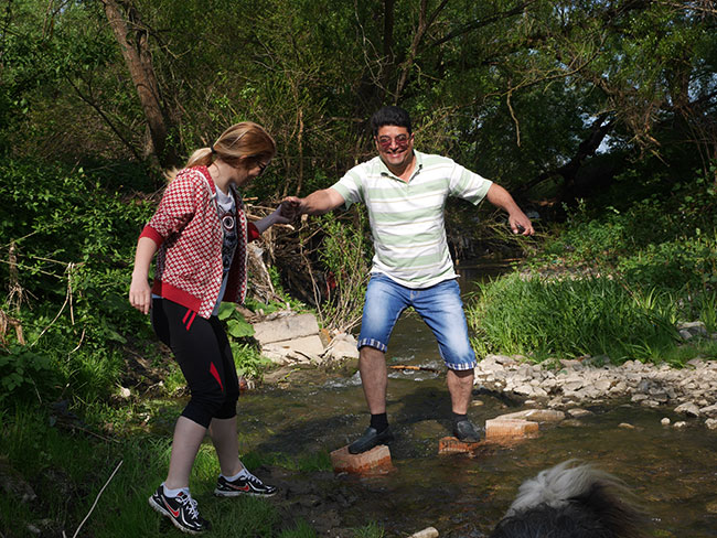Alina und Gabriel überqueren einen Fluß auf Steinen