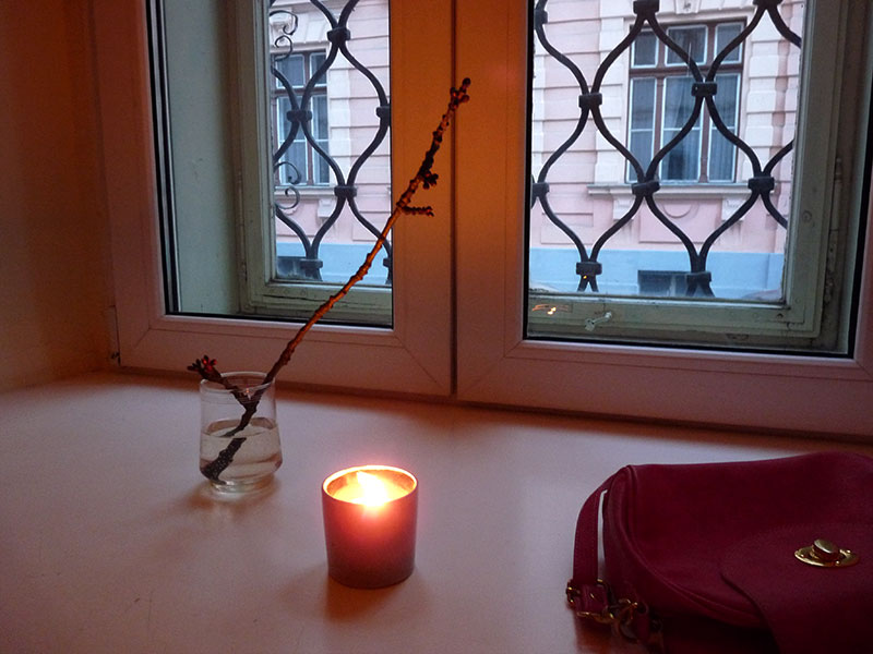 Kerze und Kirschzweig im Fenster