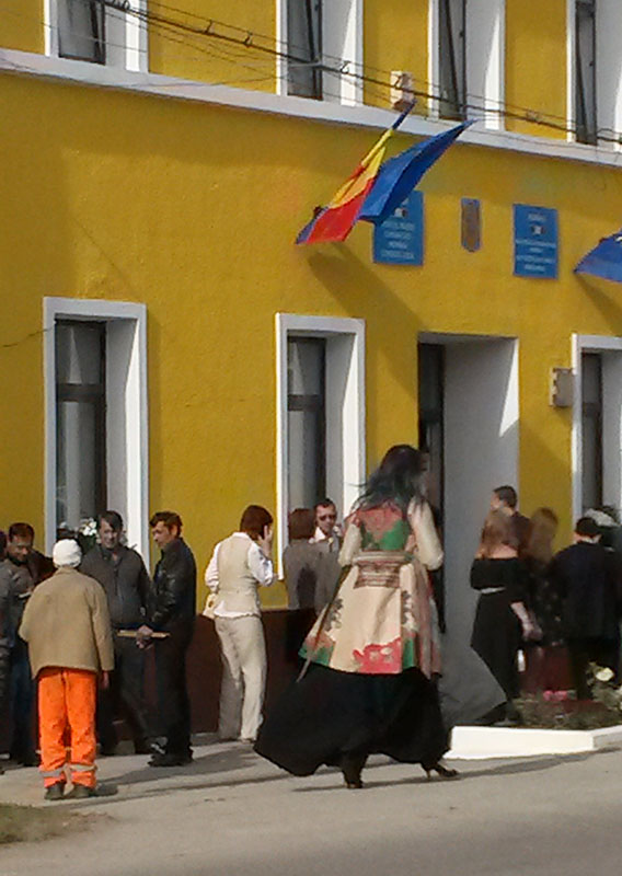 sonnengelb gestrichenes Rathaus mit Menschen davor