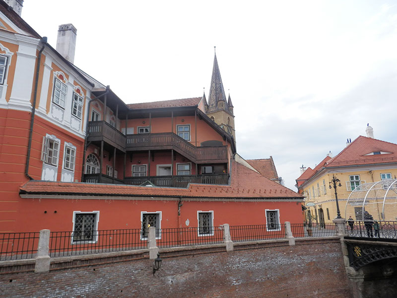 altes Fachwerkhaus mit Kirchturm im Hintergrund