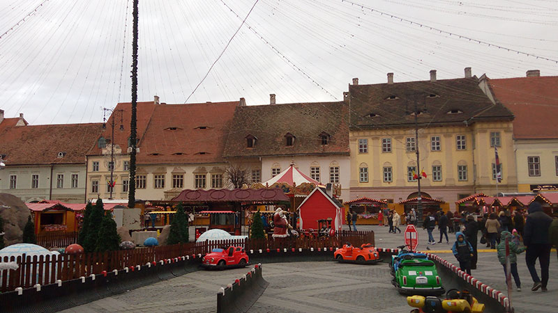 Weihnachtsmarkt mit Kinderautos im Vordergrund