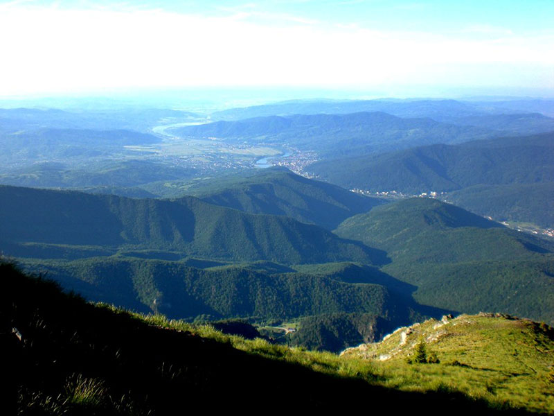 Panoramafoto in die Tiefebene mit Wälder im Vordergrund und dem Oltfluss am Horiziont